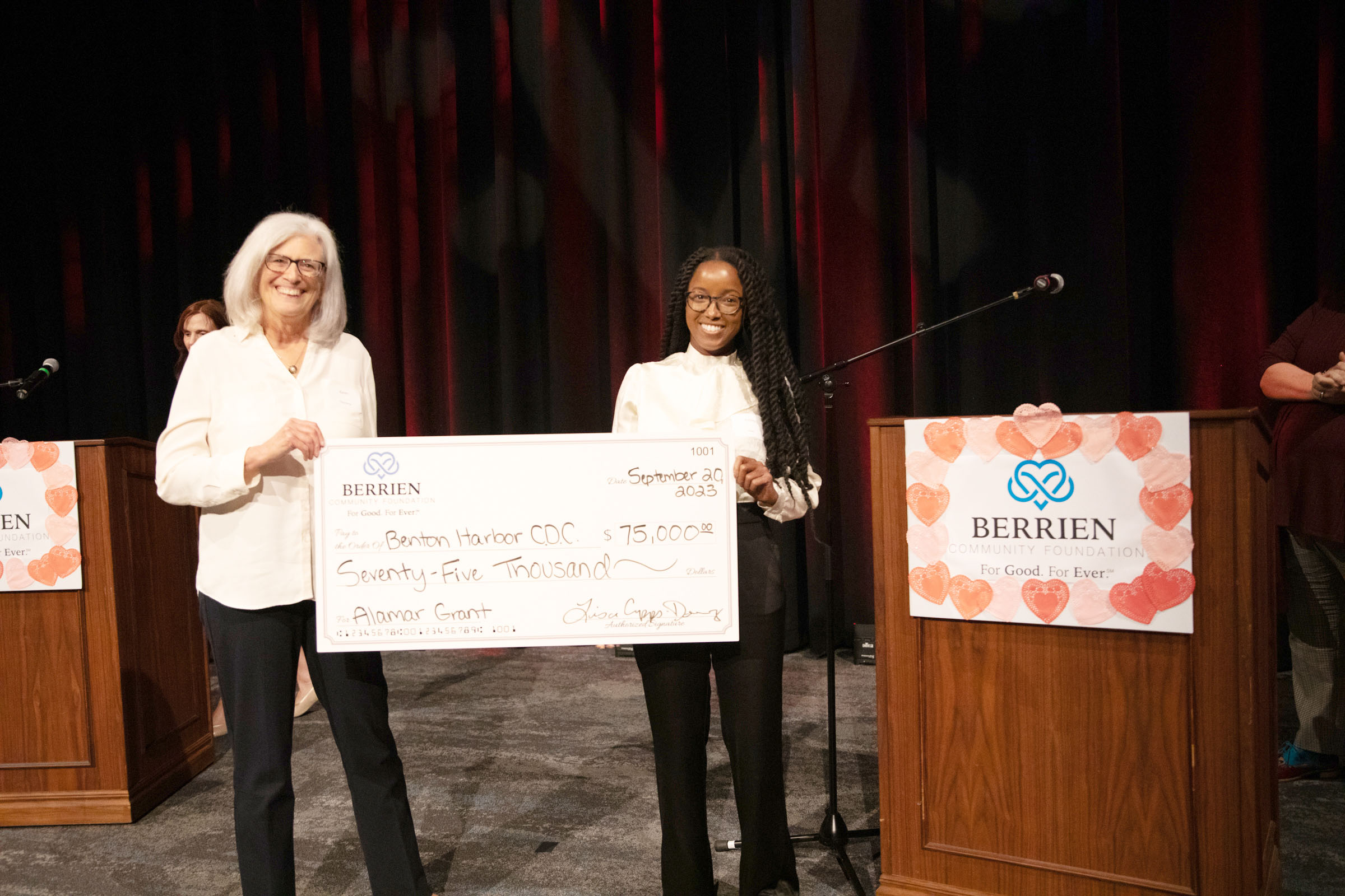 Benton Harbor Community Development Corporation Executive Director Ashley Hines and board member James Gunter hold up a $75,000 check after being announced as the winner of the Alamar Nonprofit Sustainability Grant September 20 at Berrien Community Foundation's Annual Meeting & Celebration.