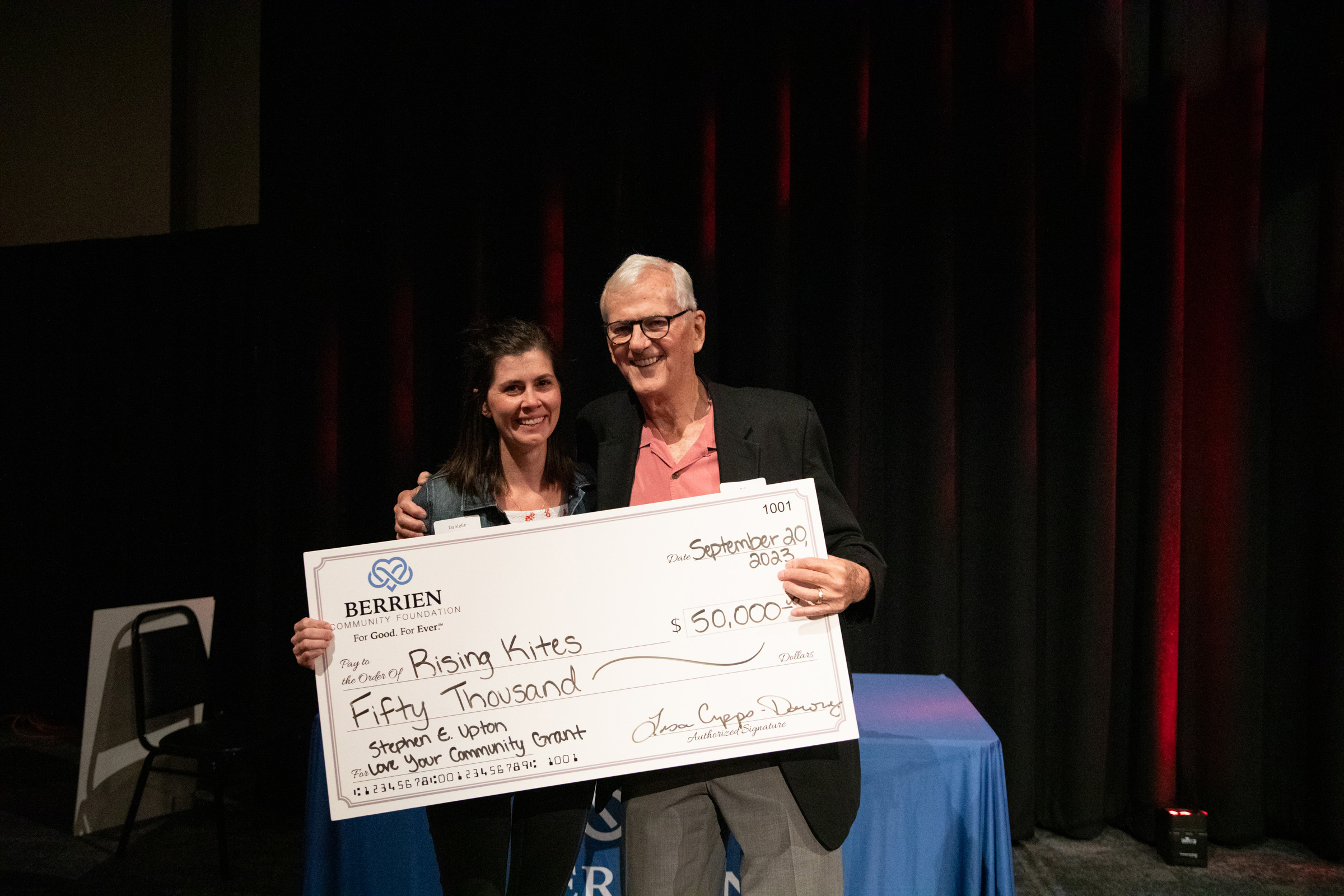 Danielle Grandholm poses with William Marohn and a $50,000 check after being announced as the winner of the Stephen E. Upton Love Your Community Grant September 20 at Berrien Community Foundation's Annual Meeting & Celebration.