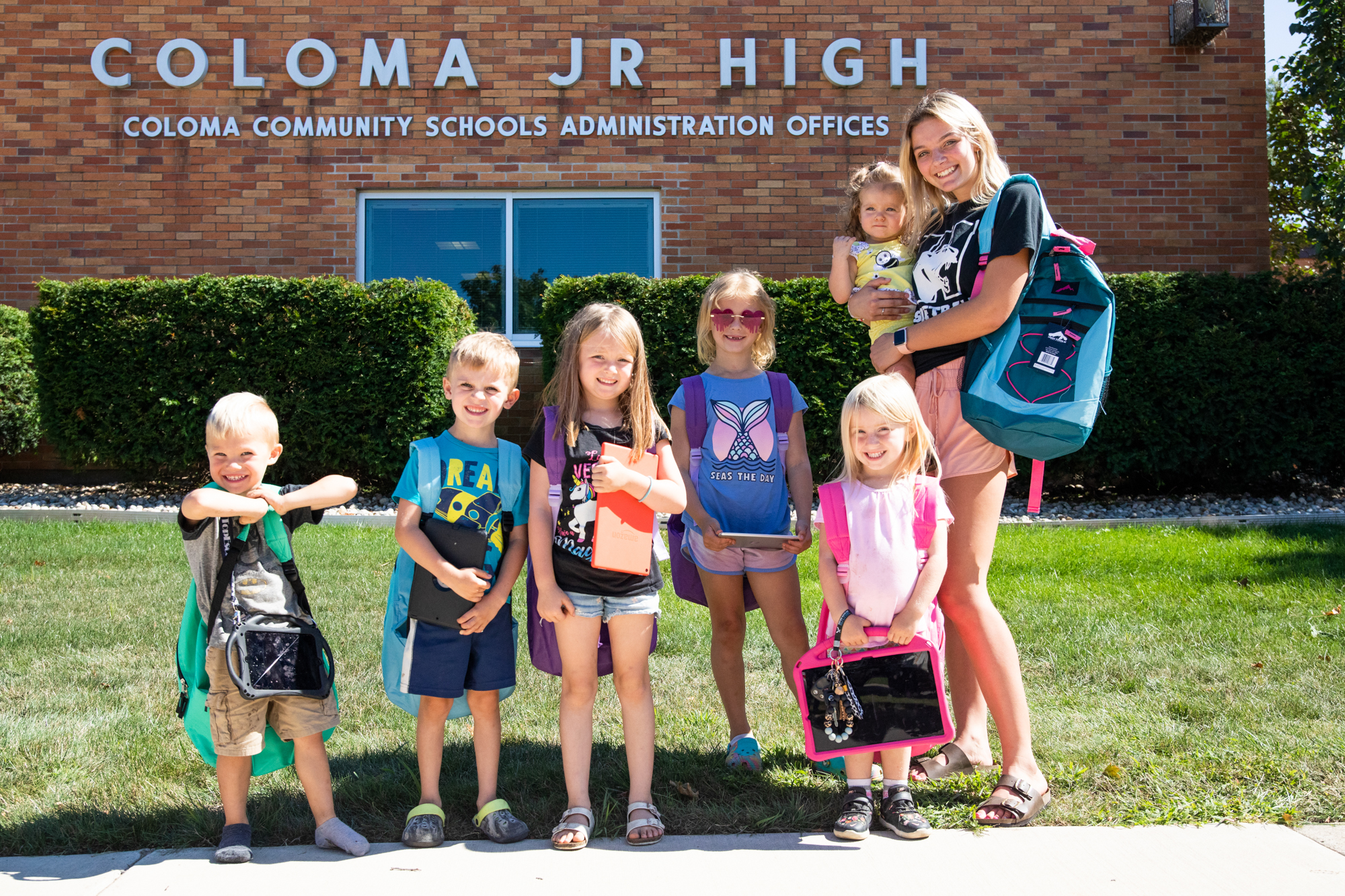 A group of school-aged students wearing backpacks. 