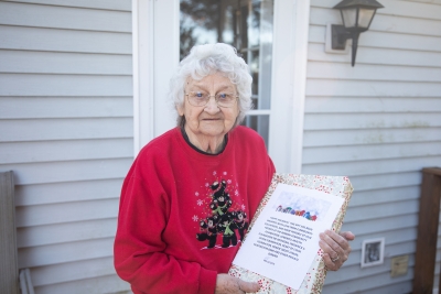 Senior citizen holding a wrapped gift.