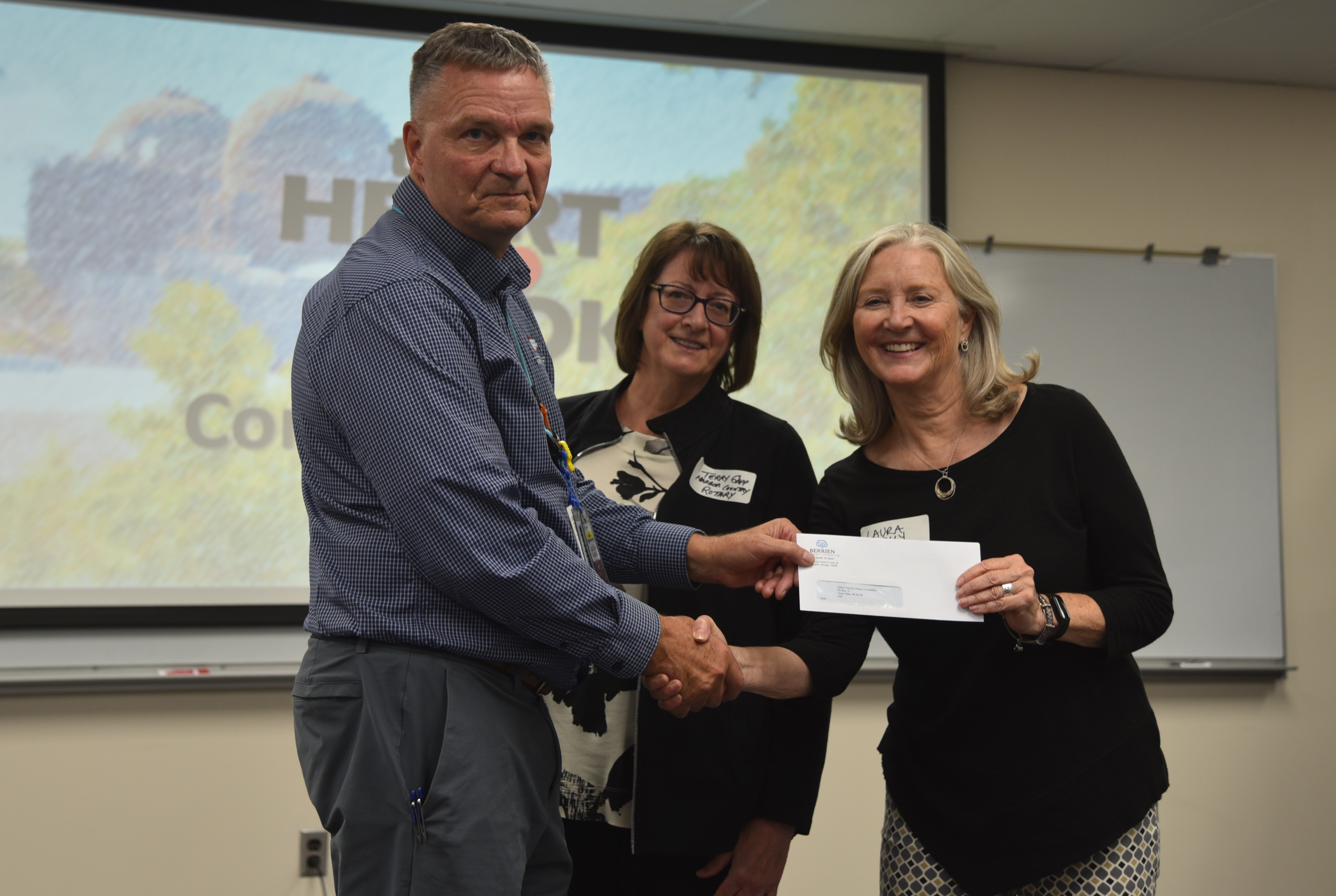 Photo of three people holding a check.