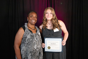 A teenager holding a certificate.