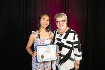A teenager holding a certificate.