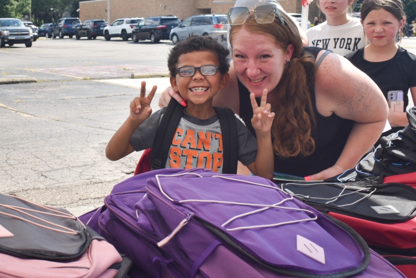A boy holding up two peace signs.