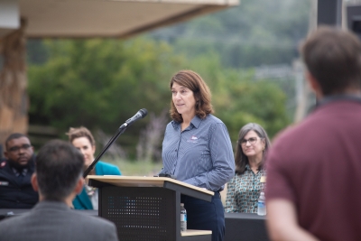 woman standing behind podium.