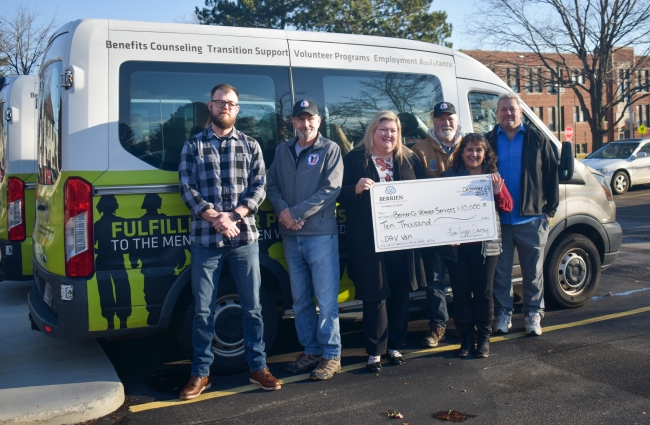 Group photo of people in front of a van.