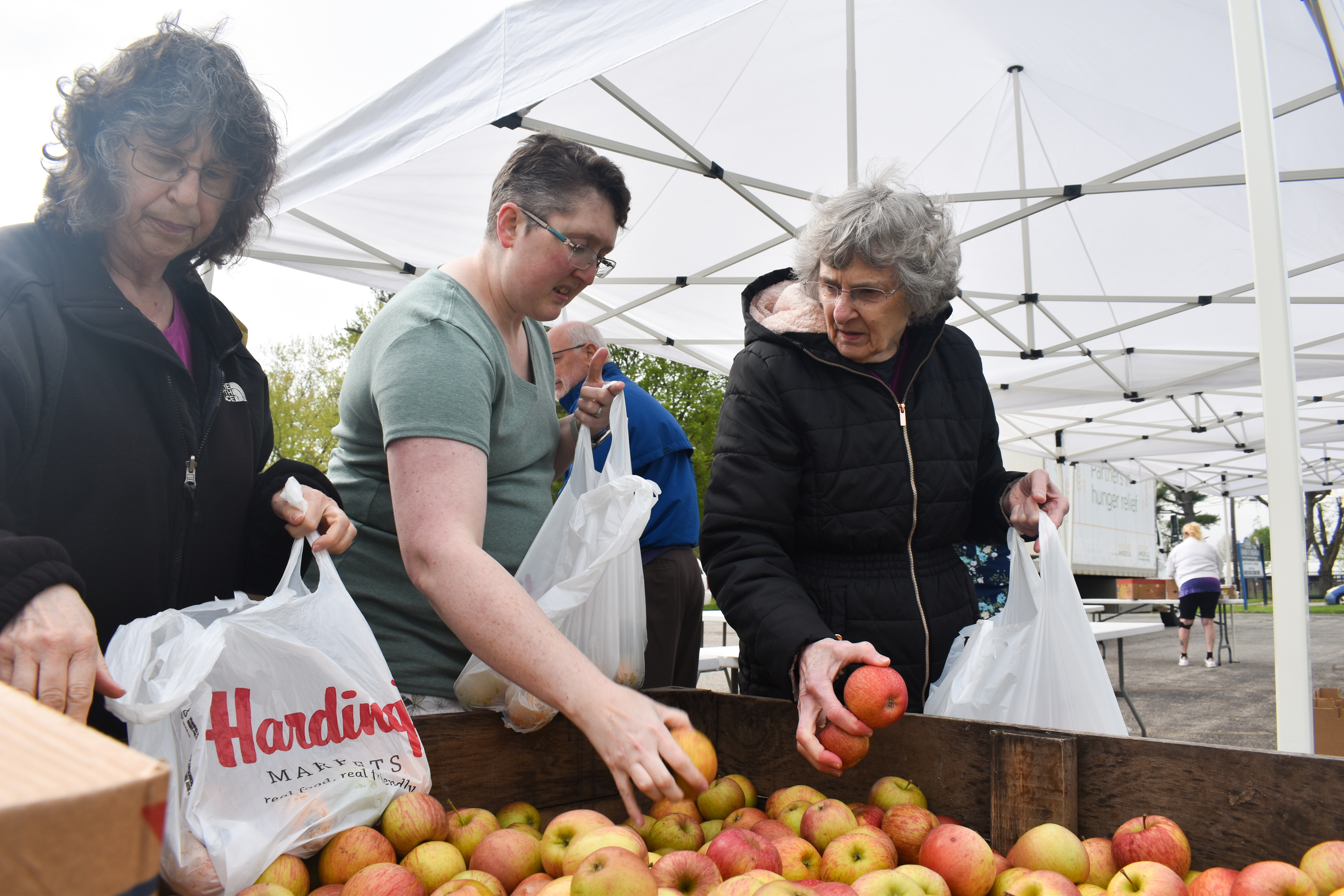 Three women picking apples.