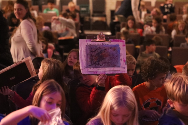 child holds up a drawing