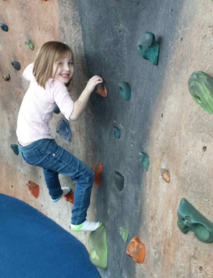 child climbing a rock wall.