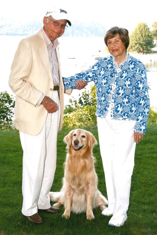 portrait of steve and elizabeth upton with a golden retriever between them.