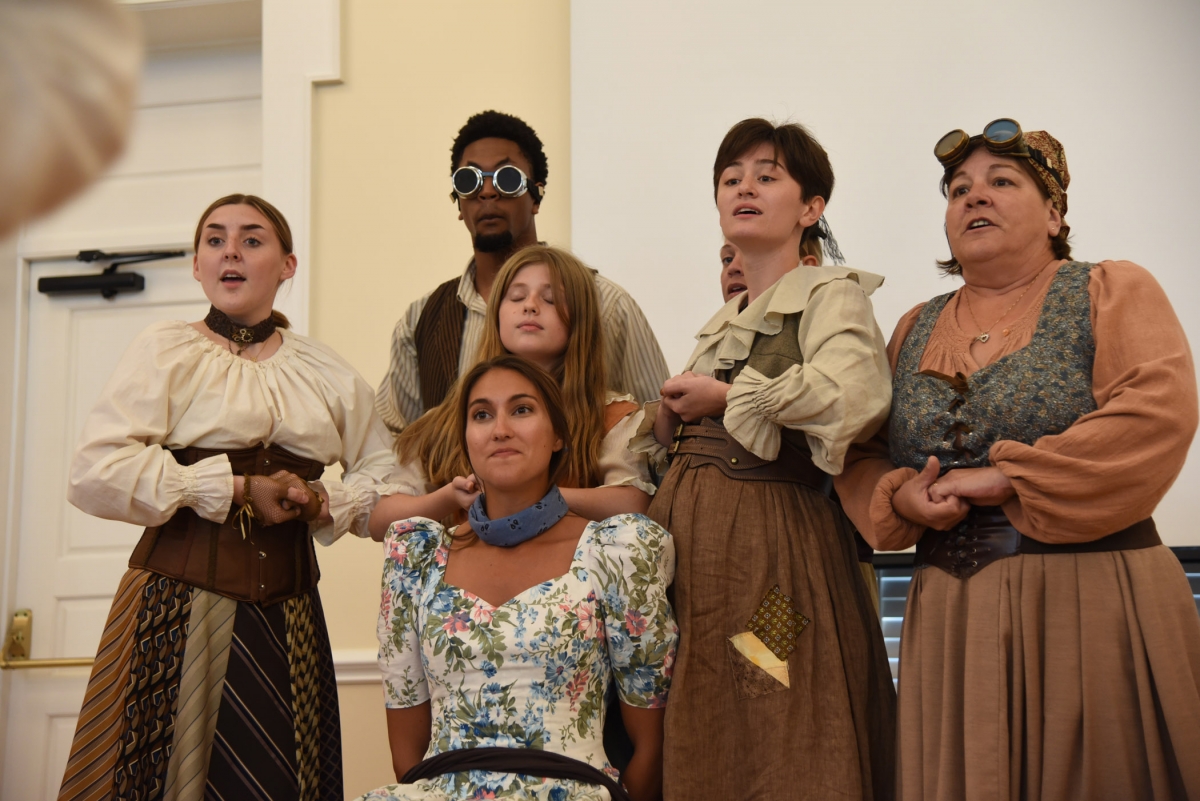 Group of people of all ages performing a sketch while wearing vintage clothing.