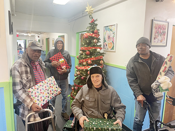 Four men showing wrapped care packages. 