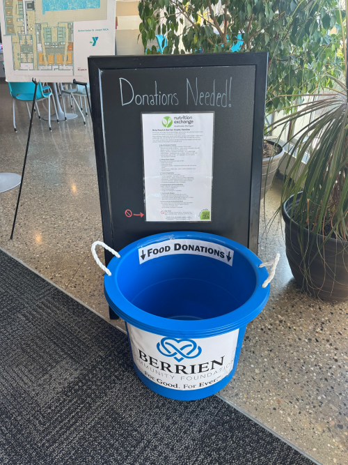 bucket under sign that says "doantions needed."