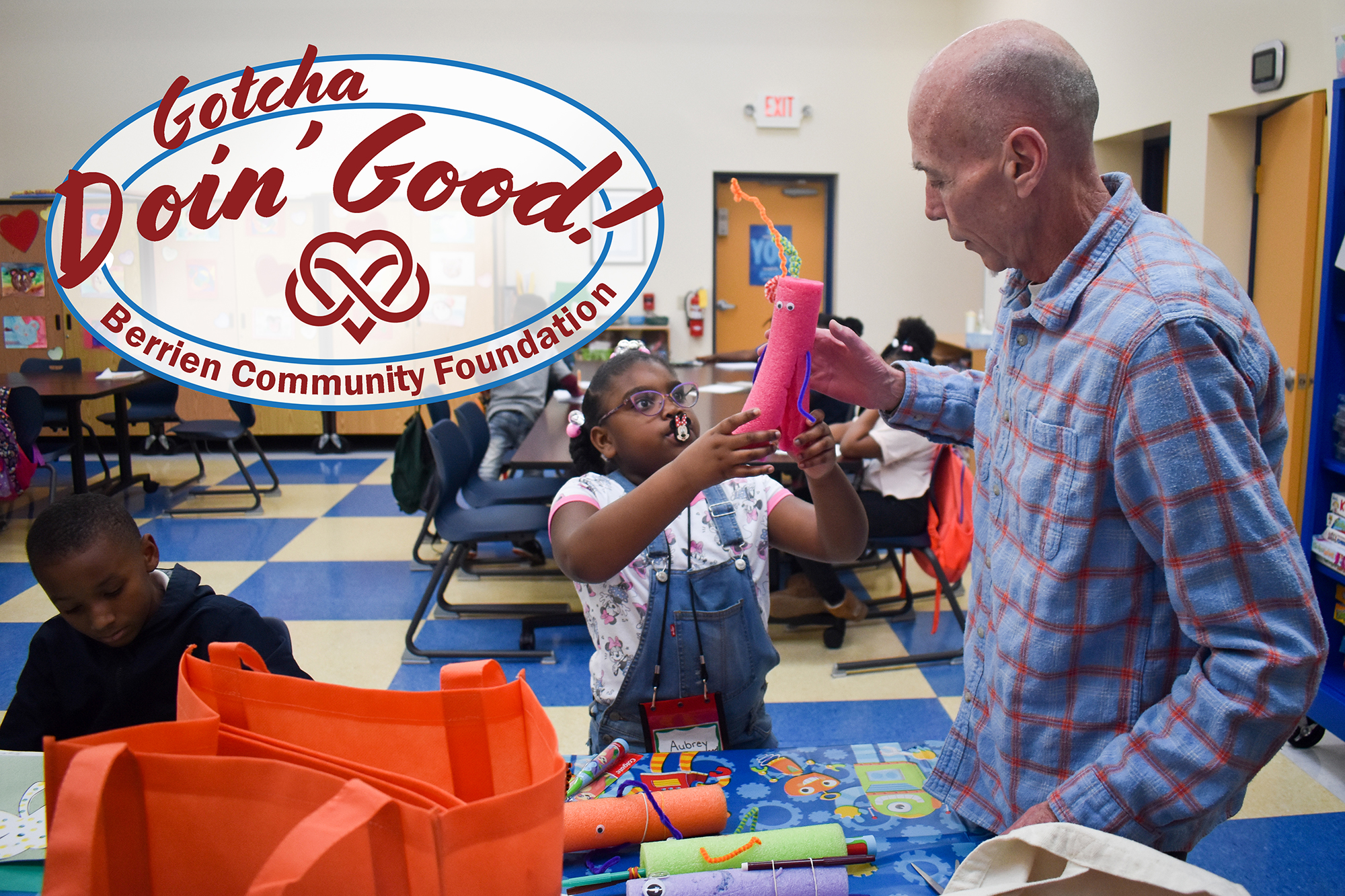 Kevin Sweeney helps a little girls with building a "drawing robot" with a pool noodle and electric toothbrush.