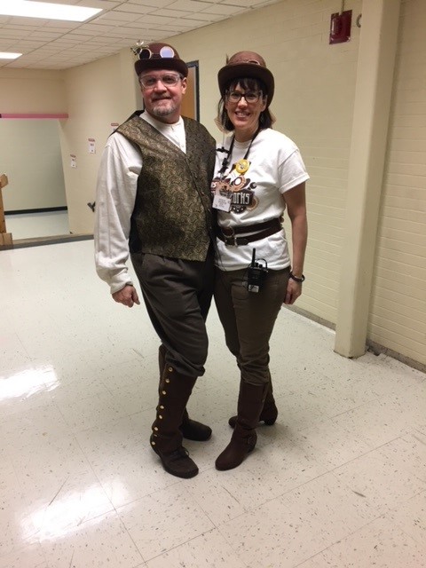 Two people standing in steampunk costumes.