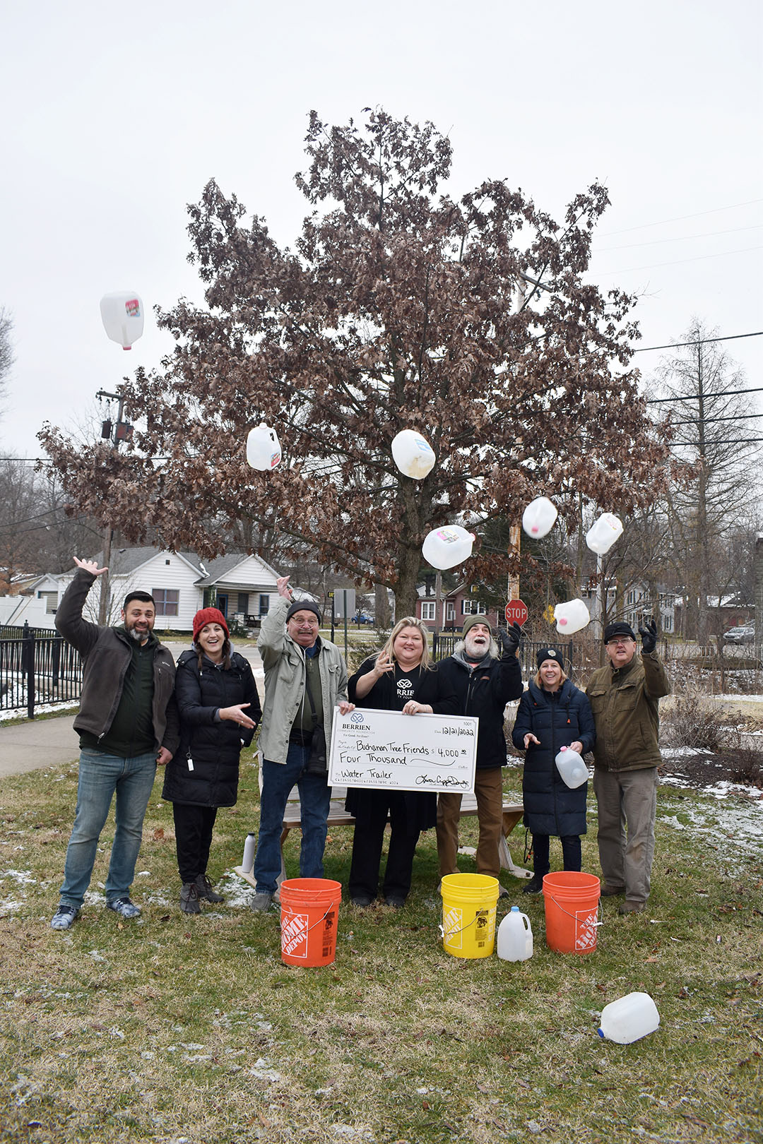 Photo of adults tossing milk jugs into the air. 