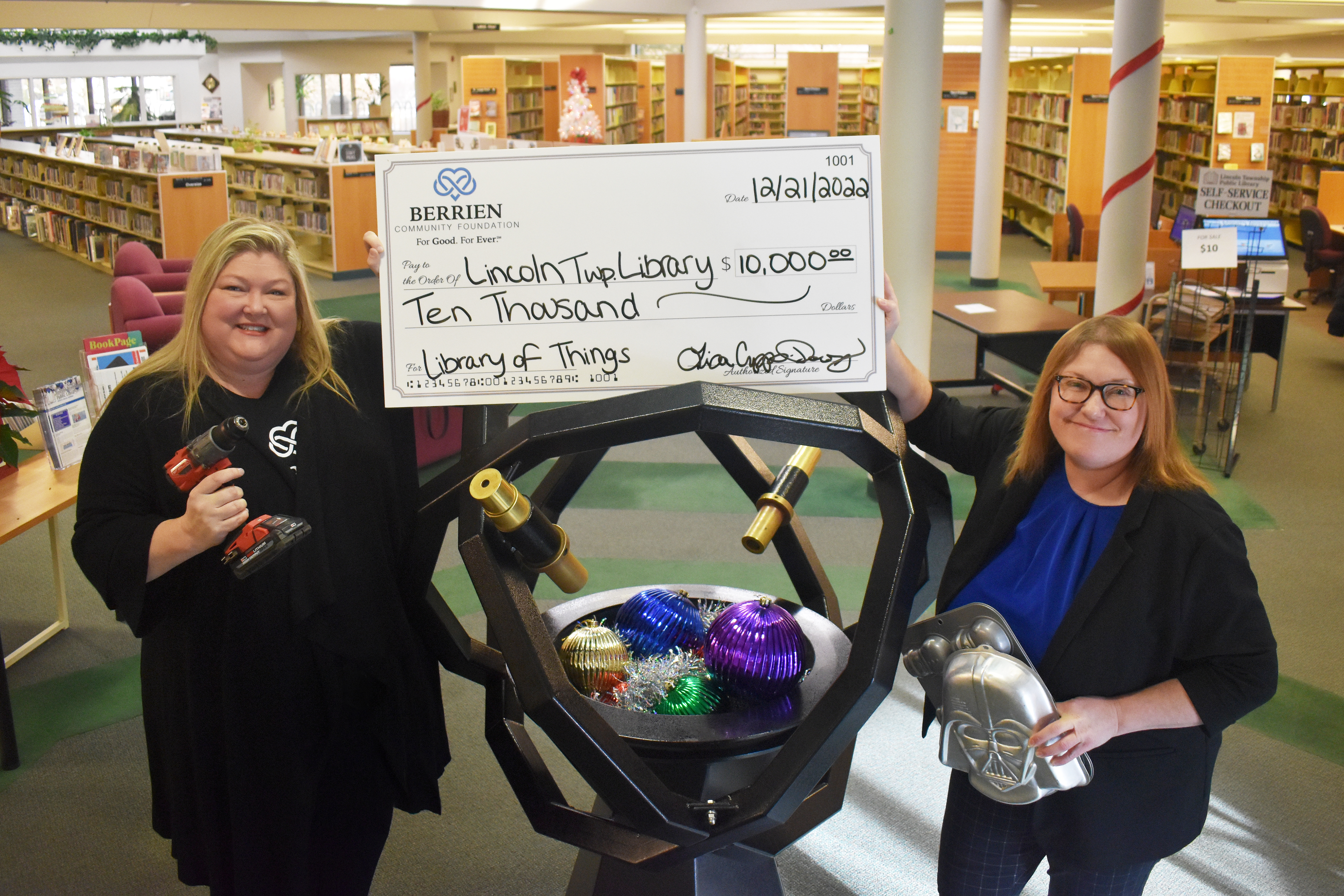 Two women holding a large check.