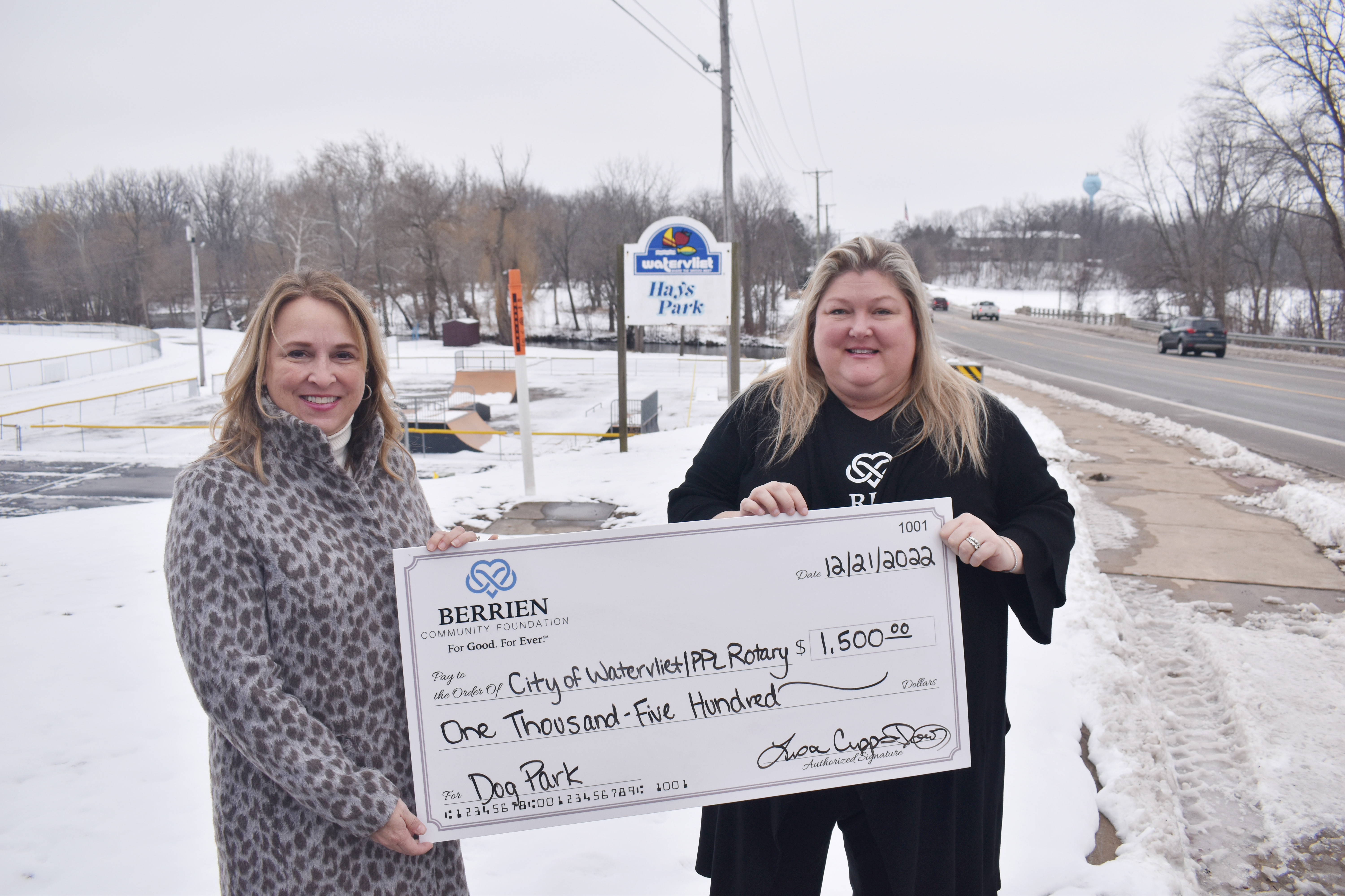 Two women holding a large check.