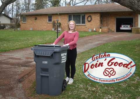 Ellie walking a trash bin out to the road.