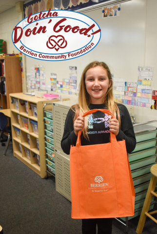 Madison holding an orange tote bag.