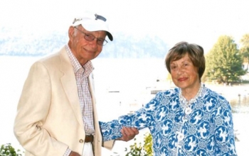 portrait of Steve Upton and Elizabeth Upton with a Golden Retriever between them.