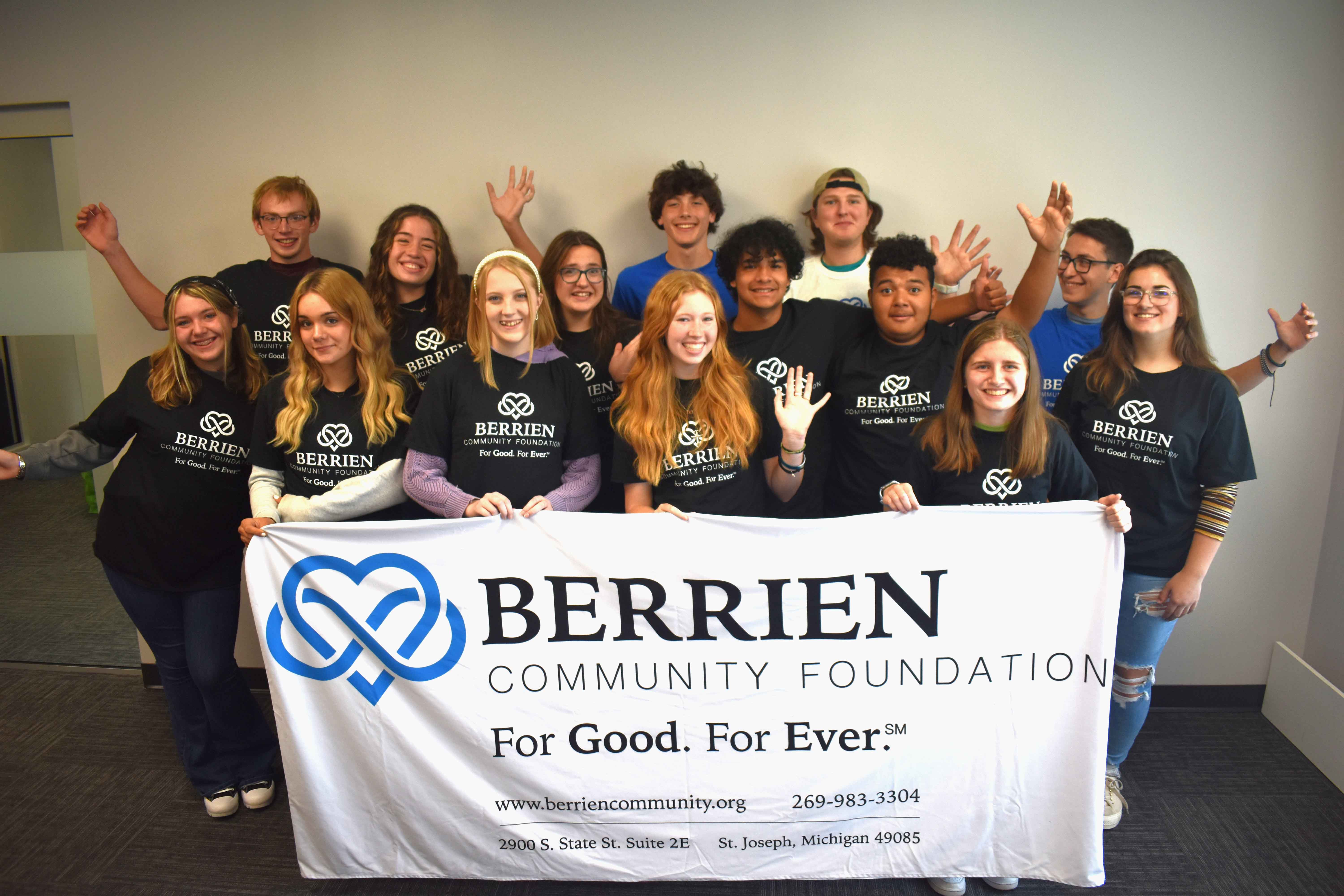 Group photo of the T.E.A.M. members holding a Berrien Community Foundation sign. 