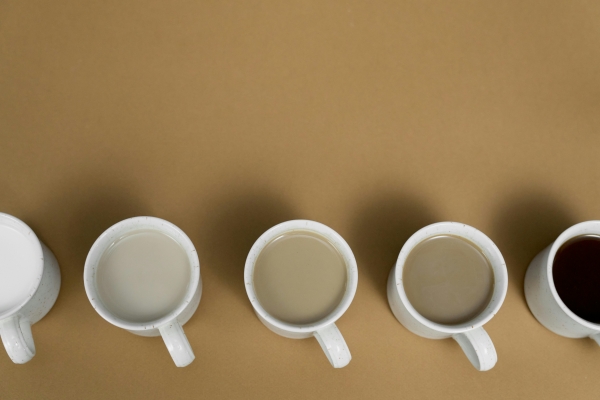An overhead view of a row of coffee-filled coffee cups.