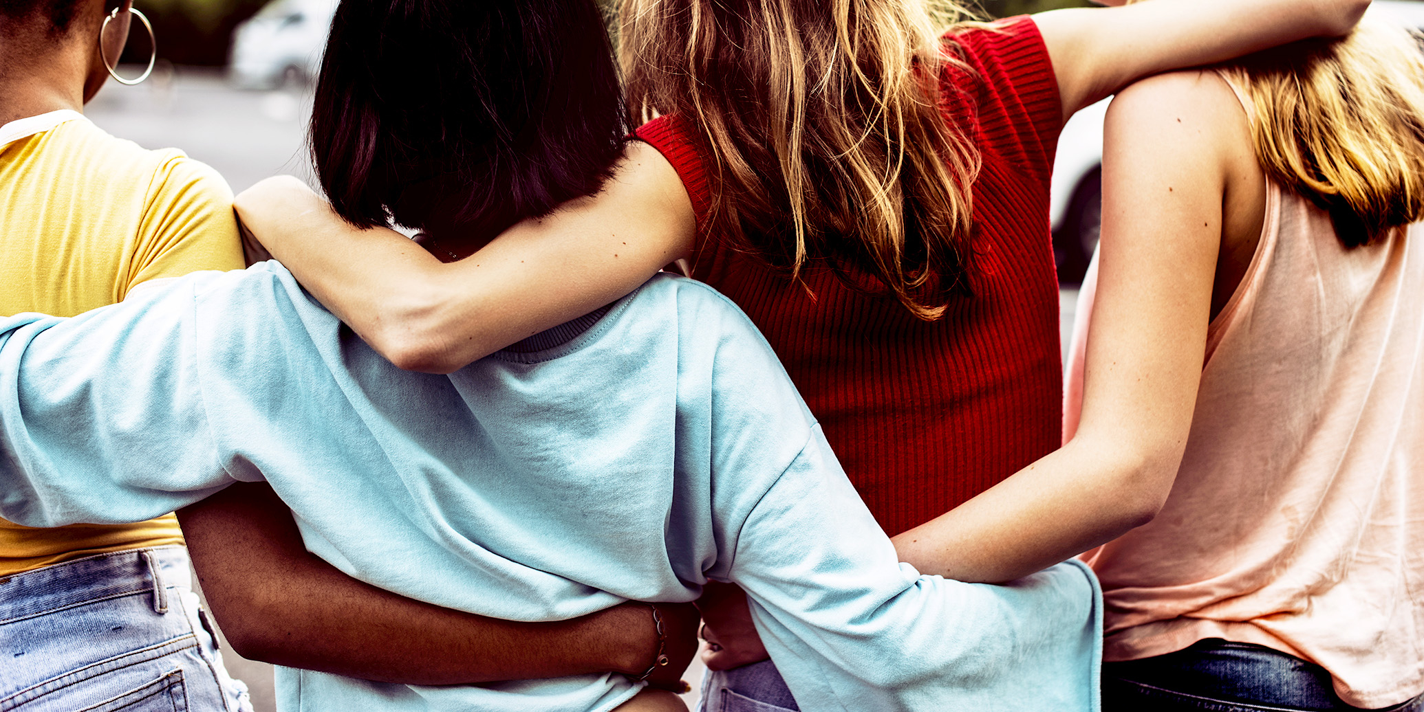 Image of women standing side-by-side hugging.